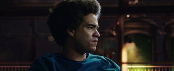 Movie still from “American Carnage” (2022), directed by Diego Hallivis – A young man with afro hair looking to his left; Close Up shot, Low angle