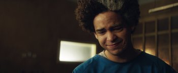 Movie still from “American Carnage” (2022), directed by Diego Hallivis – A person with curly hair; Close Up shot, Over the shoulder angle