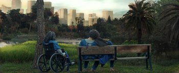Movie still from “American Carnage” (2022), directed by Diego Hallivis – A couple of people sitting on top of a wooden bench; Wide shot, Over the shoulder angle