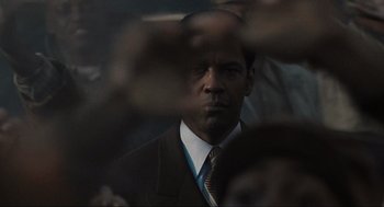 Movie still from “American Gangster” (2007), directed by Ridley Scott – A person wearing a suit and tie; Close Up shot, Low angle