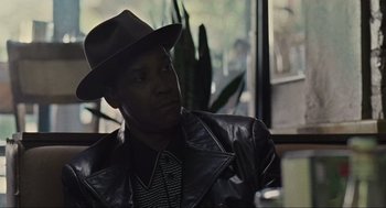 Movie still from “American Gangster” (2007), directed by Ridley Scott – A man wearing a hat and a leather jacket; Close Up shot, Over the shoulder angle