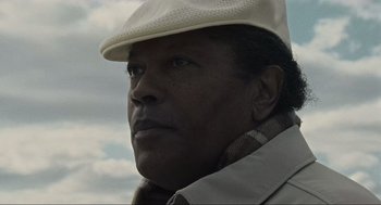 Movie still from “American Gangster” (2007), directed by Ridley Scott – A person wearing a hat; Close Up shot, Low angle