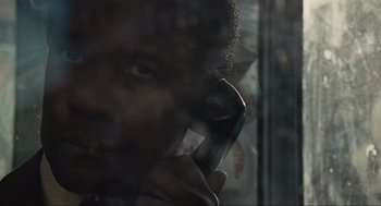 Movie still from “American Gangster” (2007), directed by Ridley Scott – A man talking on a cell phone in front of a window; Close Up shot, Low angle