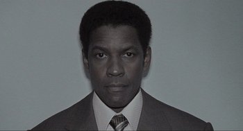 Movie still from “American Gangster” (2007), directed by Ridley Scott – A black and white photo of a man wearing a suit and tie; Close Up shot, Low angle