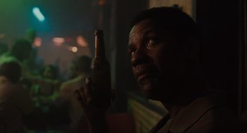 Movie still from “American Gangster” (2007), directed by Ridley Scott – A person holding a bottle of beer; Close Up shot, Low angle