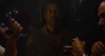 Movie still from “American Gangster” (2007), directed by Ridley Scott – A man is smoking a cigarette in the dark; Close Up shot, Over the shoulder angle