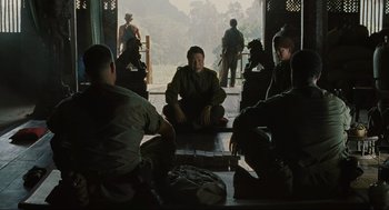 Movie still from “American Gangster” (2007), directed by Ridley Scott – A group of people sitting on a porch; Wide shot, High angle