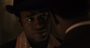 Movie still from “American Gangster” (2007), directed by Ridley Scott – A person looking at a mirror; Close Up shot, Over the shoulder angle