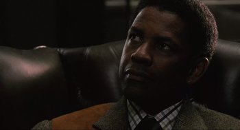 Movie still from “American Gangster” (2007), directed by Ridley Scott – A person wearing a suit and tie; Close Up shot, Low angle