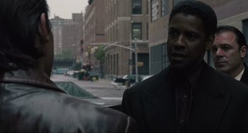 Movie still from “American Gangster” (2007), directed by Ridley Scott – A man standing in the middle of the street; Close Up shot, Over the shoulder angle