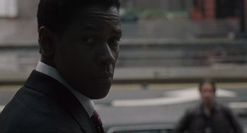 Movie still from “American Gangster” (2007), directed by Ridley Scott – A man in a suit and red tie looking to his left; Close Up shot, Over the shoulder angle