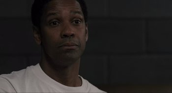 Movie still from “American Gangster” (2007), directed by Ridley Scott – A person wearing a white t - shirt; Close Up shot, Low angle