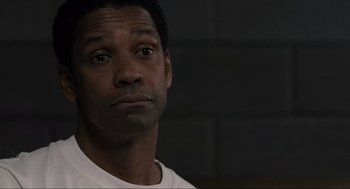 Movie still from “American Gangster” (2007), directed by Ridley Scott – A person wearing a white t - shirt; Close Up shot, Low angle