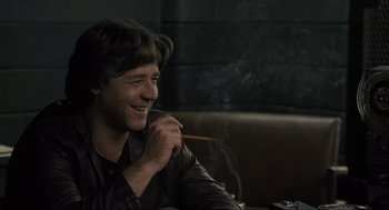 Movie still from “American Gangster” (2007), directed by Ridley Scott – A man sitting in a booth smoking a cigarette; Close Up shot, Over the shoulder angle