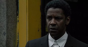 Movie still from “American Gangster” (2007), directed by Ridley Scott – A person wearing a suit and tie; Close Up shot, Over the shoulder angle