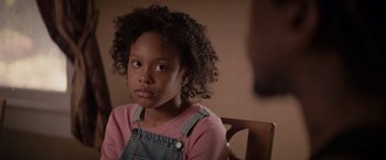 Movie still from “The Hate U Give” (2018), directed by George Tillman Jr. – A young girl sitting in a chair looking into the camera; Close Up shot, Over the shoulder angle