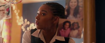 Movie still from “The Hate U Give” (2018), directed by George Tillman Jr. – A young woman with dreadlocks is looking off into the distance; Close Up shot, Over the shoulder angle