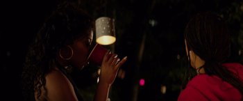 Movie still from “The Hate U Give” (2018), directed by George Tillman Jr. – A woman is drinking from a red coffee cup; Close Up shot, Over the shoulder angle