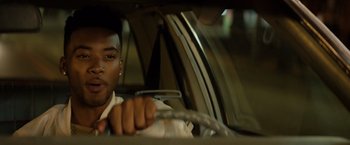 Movie still from “The Hate U Give” (2018), directed by George Tillman Jr. – A man driving a car in the back of a car; Close Up shot, Over the shoulder angle