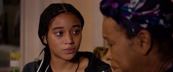 Movie still from “The Hate U Give” (2018), directed by George Tillman Jr. – A woman with braids is looking at another woman with braids; Close Up shot, Over the shoulder angle