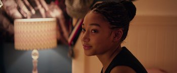 Movie still from “The Hate U Give” (2018), directed by George Tillman Jr. – A young girl is smiling for the camera; Close Up shot, Over the shoulder angle