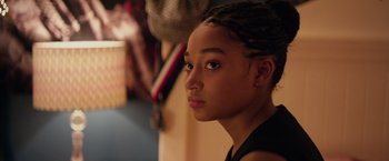 Movie still from “The Hate U Give” (2018), directed by George Tillman Jr. – A young woman with a dreadlock hair style; Close Up shot, Over the shoulder angle