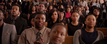 Movie still from “The Hate U Give” (2018), directed by George Tillman Jr. – A group of people sitting in front of each other in a church; Medium shot, High angle