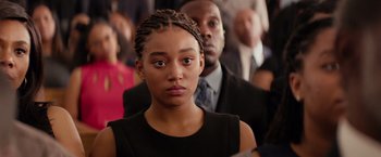 Movie still from “The Hate U Give” (2018), directed by George Tillman Jr. – A young woman with braids standing in front of a crowd; Close Up shot, Over the shoulder angle
