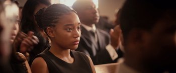 Movie still from “The Hate U Give” (2018), directed by George Tillman Jr. – A woman sitting in front of a man in a suit; Close Up shot, Over the shoulder angle