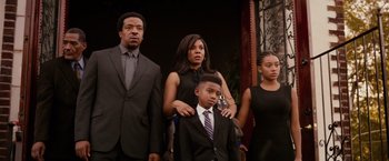 Movie still from “The Hate U Give” (2018), directed by George Tillman Jr. – A group of people standing next to each other in a room; Medium shot, Low angle