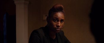 Movie still from “The Hate U Give” (2018), directed by George Tillman Jr. – A woman in a black jacket is looking at the camera; Close Up shot, Over the shoulder angle