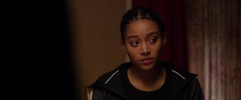 Movie still from “The Hate U Give” (2018), directed by George Tillman Jr. – A young woman with a black jacket sitting in a chair; Close Up shot, Over the shoulder angle