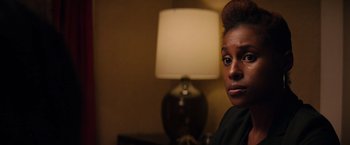 Movie still from “The Hate U Give” (2018), directed by George Tillman Jr. – A woman sitting in front of a table with a lamp; Close Up shot, Over the shoulder angle