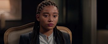 Movie still from “The Hate U Give” (2018), directed by George Tillman Jr. – A young woman sitting in a chair looking at the camera; Close Up shot, Over the shoulder angle
