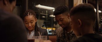 Movie still from “The Hate U Give” (2018), directed by George Tillman Jr. – A man and a woman sitting at a table with drinks; Close Up shot, Over the shoulder angle