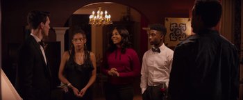 Movie still from “The Hate U Give” (2018), directed by George Tillman Jr. – A group of young people standing in a room together; Medium shot, Over the shoulder angle