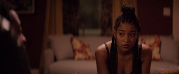 Movie still from “The Hate U Give” (2018), directed by George Tillman Jr. – A woman sitting on a couch in front of a window; Close Up shot, Over the shoulder angle