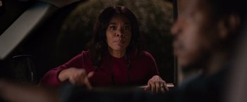 Movie still from “The Hate U Give” (2018), directed by George Tillman Jr. – A woman in a red shirt is sitting at a table; Close Up shot, Over the shoulder angle