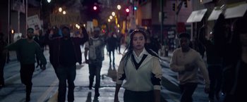 Movie still from “The Hate U Give” (2018), directed by George Tillman Jr. – A woman is walking down the street at night; Medium shot, Low angle
