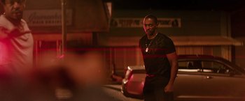 Movie still from “The Hate U Give” (2018), directed by George Tillman Jr. – A man walking down the street at night; Medium shot, Over the shoulder angle