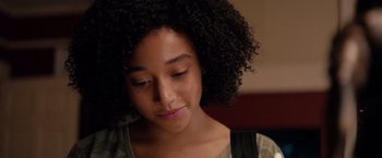 Movie still from “The Hate U Give” (2018), directed by George Tillman Jr. – A person with curly hair looking down; Close Up shot, Over the shoulder angle
