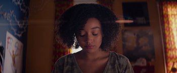 Movie still from “The Hate U Give” (2018), directed by George Tillman Jr. – A young woman with her eyes closed with her eyes closed; Close Up shot, Low angle