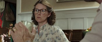 Movie still from “American Sniper” (2014), directed by Clint Eastwood – A woman in glasses and a floral shirt is holding a piece of paper; Close Up shot, Over the shoulder angle