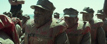 Movie still from “American Sniper” (2014), directed by Clint Eastwood – A group of men standing next to each other on a beach; Close Up shot, High angle