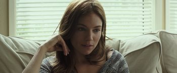 Movie still from “American Sniper” (2014), directed by Clint Eastwood – A beautiful woman sitting on a couch with her hand on her head; Close Up shot, Over the shoulder angle
