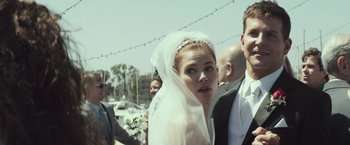 Movie still from “American Sniper” (2014), directed by Clint Eastwood – A woman wearing a veil standing in front of a group of people; Close Up shot, Over the shoulder angle