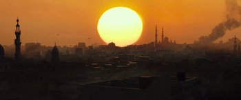 Movie still from “American Sniper” (2014), directed by Clint Eastwood – The sun is setting over a large city; Extreme Wide shot, Low angle