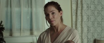 Movie still from “American Sniper” (2014), directed by Clint Eastwood – A woman holding a baby in her arms; Close Up shot, Over the shoulder angle