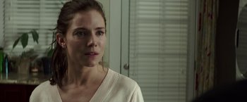 Movie still from “American Sniper” (2014), directed by Clint Eastwood – A person wearing a white shirt near a window; Close Up shot, Over the shoulder angle