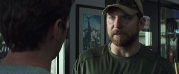 Movie still from “American Sniper” (2014), directed by Clint Eastwood – A man with a beard wearing a hat and looking into a mirror; Close Up shot, Over the shoulder angle